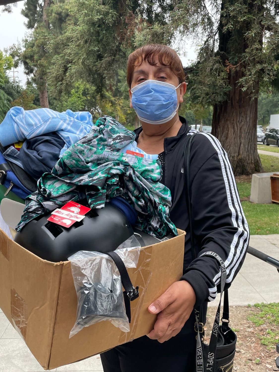 PHOTO: Sally Kilby | The South Pasadenan | Sylvia Magallanes leaves War Memorial Building on the first day of the May South Pasadena Tournament of Roses yard sale with a box filled with useful items. She also bought a bicycle that day and then returned on the second day to shop further. 